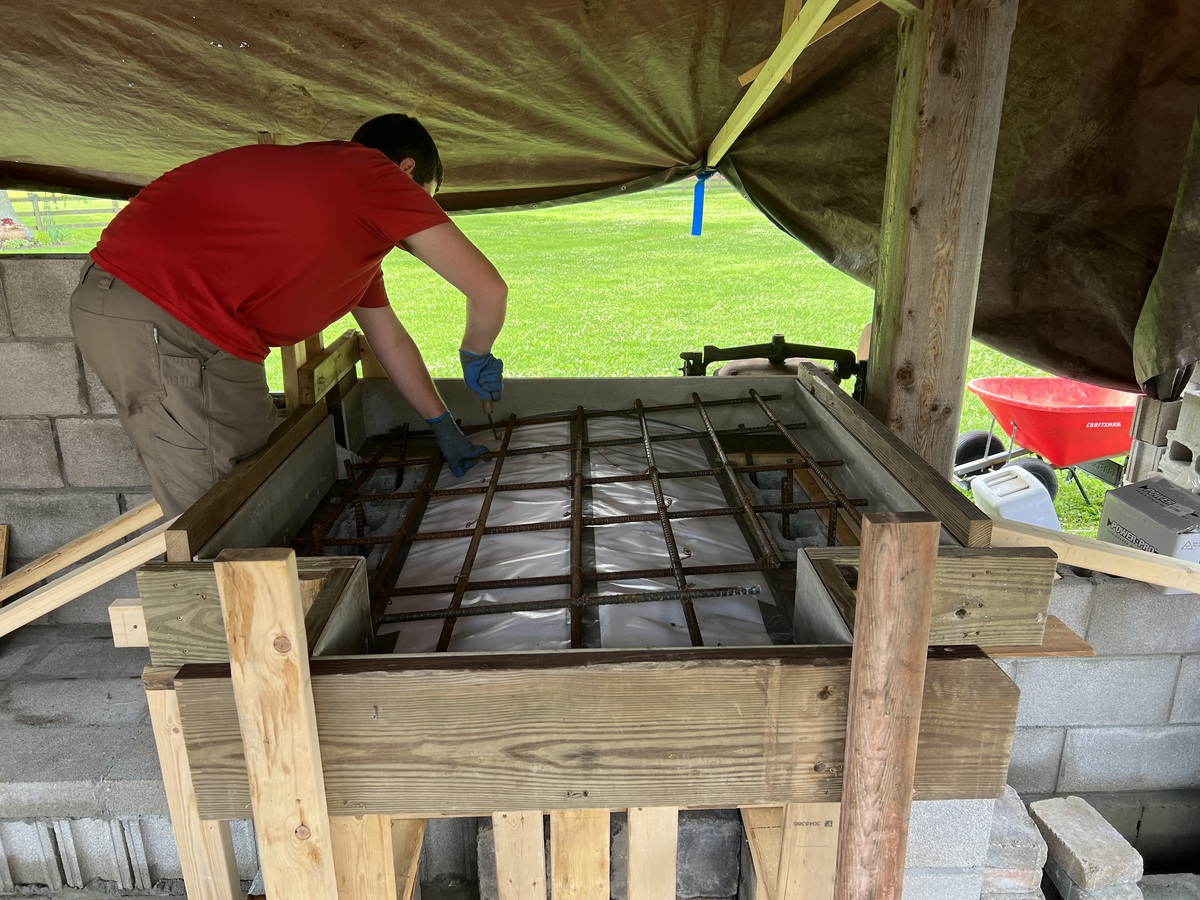 a guy working on the pizza oven