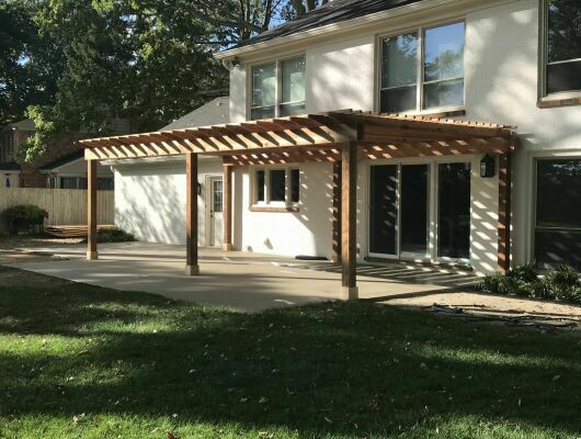 The sun shining on a pergola on an outdoor patio