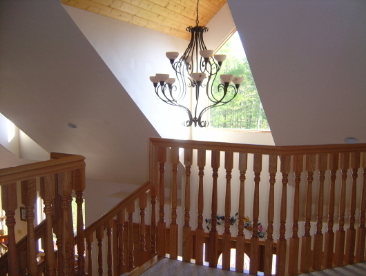 tan stair railing and chandelier