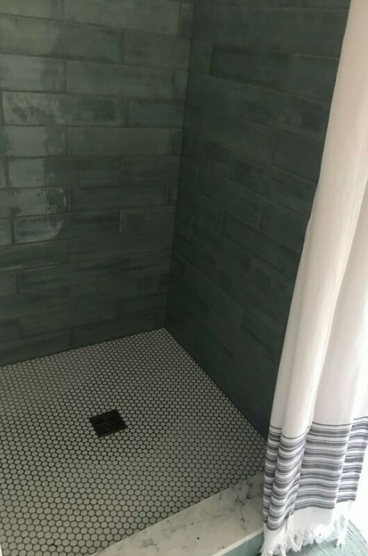shower floor with white tile and blue wall tile