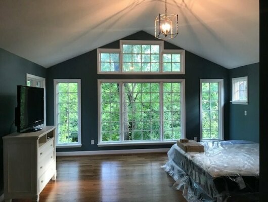 bedroom with blue walls, lots of windows, and chandelier