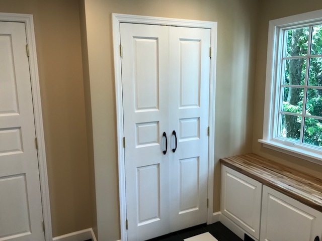 white doors with block handles opening to closet